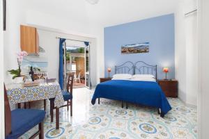 a blue bedroom with a bed and a table at Sorrento Marida Rooms in Sorrento