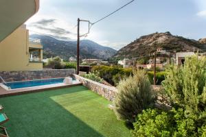 a backyard with a lawn and a swimming pool at Kytaion Premium Residence with private Pool in Agia Pelagia