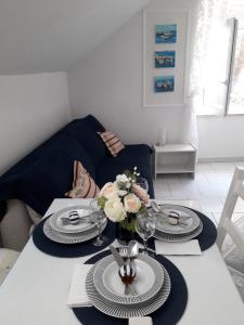 a dining room table with plates and a vase of flowers at Apartment Josip in Korčula