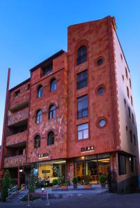 a large red brick building with windows on it at Bass Boutique Hotel in Yerevan