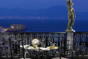 a table with a statue of a woman on a balcony at Grand Hotel Parker's in Naples