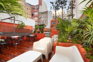 eine Außenterrasse mit Tischen, Stühlen und Pflanzen in der Unterkunft Enjoybcn Patio de Gracia in Barcelona