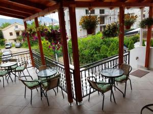 a patio with tables and chairs and a balcony at Sobe Nedović in Budva