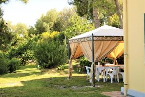 a table and chairs under a tent in a garden at Antico Portale in Ascea