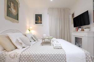 羅馬的住宿－Cave98 Apartment，一间白色卧室,配有一张白色的床和壁炉