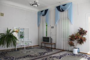 a living room with a television and a table at Zheleznovodskaya Klinika Sanatorium in Zheleznovodsk
