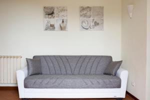 a couch in a room with pictures on the wall at Casa Vacanze Tra Le Mura in Levanto