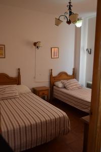 カスティブランコ・デ・ロス・アロヨスにあるCaserío de Vazquez 2のベッドルーム1室(ベッド2台、シャンデリア付)