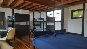 a bedroom with a bed and bunk beds with a table at Asobi Lodge in Kyotango