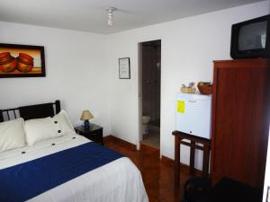 Hotel Casa Sarita في بوغوتا: غرفة نوم فيها سرير وتلفزيون