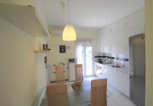 a kitchen with a table and chairs and a refrigerator at Emotion Apartments in Asprovalta +7 photos