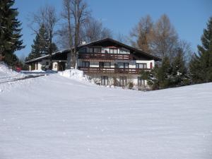 una casa en la cima de una colina nevada en Ferienwohnung Tschengla mit eigener Sonnenterrasse - Wiese - Wlan - Netflix, en Bürserberg
