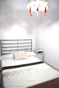 Schlafzimmer mit einem Bett und einem Kronleuchter in der Unterkunft Apartamento Feria 2 in Sevilla