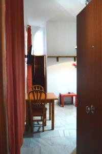 ein Wohnzimmer mit einem Tisch und einem Stuhl in der Unterkunft Apartamento Feria 2 in Sevilla