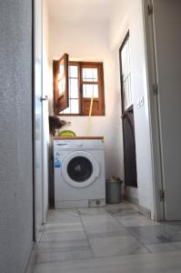 a washing machine in a laundry room with a window at Ático Feria in Seville