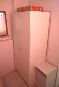 a white cabinet in a pink room with a mirror at Ático Feria in Seville