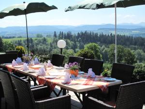 einen Tisch mit Stühlen und einem Sonnenschirm auf einer Terrasse in der Unterkunft Berghotel Jägerhof ****S in Isny im Allgäu