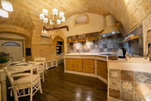 a kitchen with a sink and a table and chairs at L' alcova di Federico in Trani