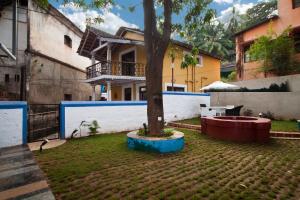 a tree in a yard in front of a building at Hospedaria Abrigo De Botelho in Panaji