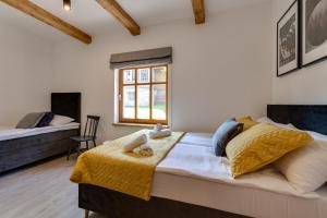 1 dormitorio con 1 cama con manta amarilla y ventana en Biała Owieczka B&B Szczyrk en Szczyrk
