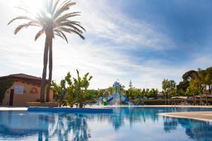 una piscina con palmeras y un parque acuático en Camping La Llosa, en Cambrils
