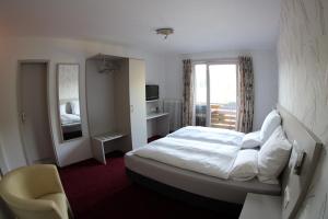 - une chambre d'hôtel avec un lit et un miroir dans l'établissement Hotel-Pension Waldhaus, à Bad Grund