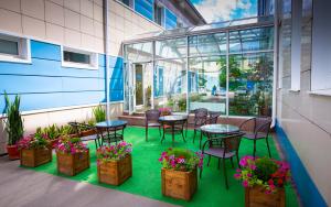 a patio with tables and chairs and potted plants at Wellness Hotel in Tula