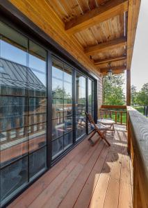 eine große Terrasse mit Glasfenstern und einer Bank in der Unterkunft Prie Lukos ezero in Trakai