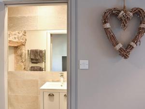 a heart shaped wreath on the wall of a bathroom at secret cottage in Sedbergh