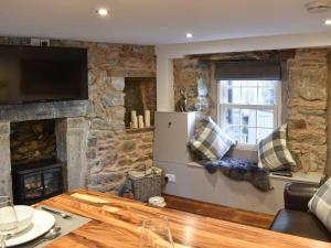 sala de estar con pared de piedra en secret cottage, en Sedbergh