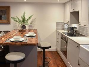 a kitchen with a wooden counter top with stools at secret cottage in Sedbergh