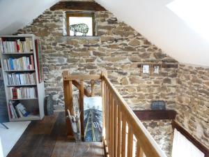 a staircase in a stone wall with a window and a book shelf at Chambre D Hôtes dans maisonnette indépendante in Saint-Sornin-Lavolps