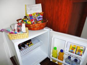 an open refrigerator with drinks and snacks in it at Hotel Casa Sarita in Bogotá