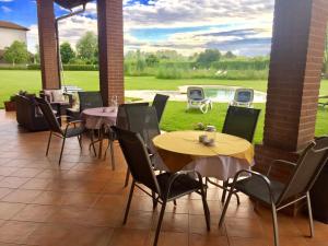 un patio con mesas y sillas y una piscina en Motel Cosmera en Savigliano