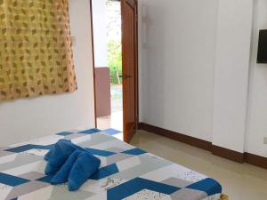 sypialnia z łóżkiem z niebieskimi poduszkami w obiekcie Za Priscila Tourist Inn w mieście Anda