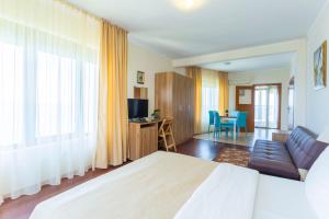 a bedroom with a bed and a couch and a table at La Casa Primorsko in Primorsko +94 photos