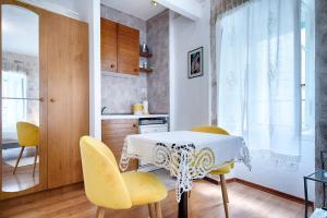 eine Küche mit einem Tisch und gelben Stühlen in der Unterkunft Villa Kuljis in Komiža