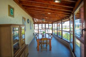 a dining room with a table and chairs and windows at La Casa Primorsko in Primorsko