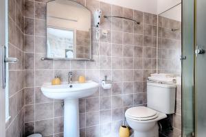 a bathroom with a toilet and a sink and a mirror at Villa Kuljis in Komiža