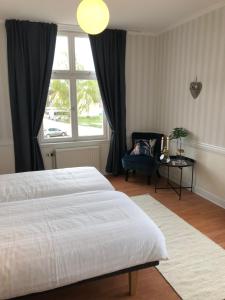 a bedroom with a bed and a chair and a window at Ydre BnB in Österbymo