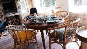 a wooden table in a room with chairs and a fireplace at La Grange in Rânes