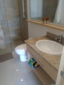 y baño con lavabo, ducha y aseo. en Apartamentos Reserva del Mar, en Santa Marta