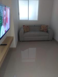 sala de estar con sofá y TV de pantalla plana en Apartamentos Reserva del Mar, en Santa Marta