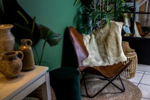 een stoel met een deken in een kamer met planten bij The BLOOM in Noordwijk aan Zee