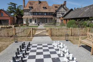 un tablero de ajedrez frente a una casa en Le manoir des chevaux dorés en Le Neubourg