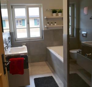 uma casa de banho com uma banheira, um lavatório e um WC. em Bodenschneid Suiten Ringbergblick em Rottach-Egern