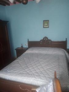 Ce lit se trouve dans une chambre dotée d'un mur bleu. dans l'établissement Magrignano, à Montieri