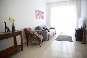 a living room with a couch and a chair at Apartamento novo 3 quartos in Diamantina