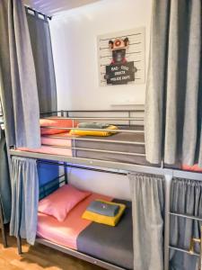 Ce lit superposé se trouve dans un dortoir doté de rideaux. dans l'établissement Live Lisboa Hostel, à Lisbonne