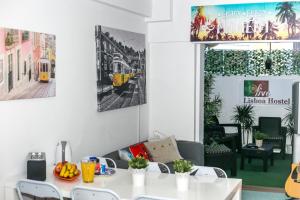 una sala da pranzo con tavolo e sedie bianchi di Live Lisboa Hostel a Lisbona